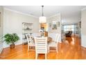 Bright dining room featuring hardwood floors, white wainscoting, a round table, and decorative shelving at 126 Star Flower Ct, Apex, NC 27539