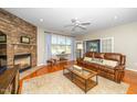 Living room showcases a stone fireplace, hardwood floors, and a comfortable leather sofa at 126 Star Flower Ct, Apex, NC 27539