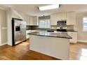 Bright kitchen with white cabinets, stainless appliances, granite countertops and hardwood flooring at 128 Barclay Rd, Durham, NC 27712
