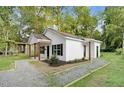 One-story home with black shutters, fresh landscaping, gravel driveway, and a welcoming front porch at 1286 W Blackman Rd, Dunn, NC 28334