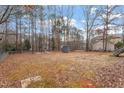 Large backyard with mature trees, a storage shed, and ample space for outdoor activities at 129 Shawnee Dr, Louisburg, NC 27549