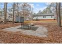 Backyard featuring a brick-lined seating area and a fire pit, surrounded by natural foliage at 129 Shawnee Dr, Louisburg, NC 27549