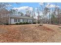 Quaint home with a long driveway and a view of the surrounding wooded area at 129 Shawnee Dr, Louisburg, NC 27549