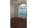 Inviting bedroom with arched window, hardwood floors, and soft natural light at 1906 Hawfields Crossing Ln, Mebane, NC 27302