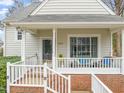 Inviting front porch with white railings, brick foundation, and outdoor seating for relaxing at 1928 Jupiter Hills Ct, Raleigh, NC 27604