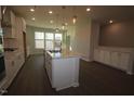 Open kitchen with island, stainless appliances, and pendant lighting at 2323 Bay Minette Sta # 547, Apex, NC 27502