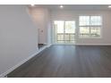Bright living room showcasing sliding glass door leading to deck and modern gray flooring at 2323 Bay Minette Sta # 547, Apex, NC 27502