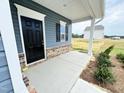 A welcoming porch with a black front door and neutral brick accents at 253 Deodora Ln, Cameron, NC 28326