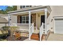 Inviting front porch with stone accents, white railings, and a cozy entrance to the home at 264 Farrington Dr, Clayton, NC 27520