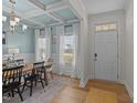 Inviting dining room featuring a coffered ceiling, updated light fixture, and natural light at 277 Martins Mill Ct, Wendell, NC 27591