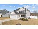 Attractive two-story home with a white exterior, black shutters, and well-maintained landscaping at 277 Martins Mill Ct, Wendell, NC 27591