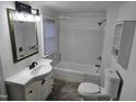 Bright white bathroom with a new toilet, sink, vanity, new flooring, and bathtub at 301 Wilson St, Franklinton, NC 27525