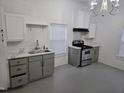 Bright kitchen featuring grey cabinets, stainless steel appliances, and a white backsplash and countertops at 301 Wilson St, Franklinton, NC 27525