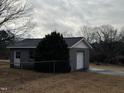 View of detached block building with a garage door and entry door at 3211 Kipling Rd, Fuquay Varina, NC 27526
