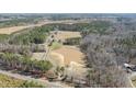 Expansive property featuring a large pond, surrounded by lush greenery and mature trees at 4050 Cannady Mill Rd, Kittrell, NC 27544