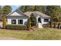 Charming white brick home with black shutters and lush landscaping providing beautiful curb appeal at 4050 Cannady Mill Rd, Kittrell, NC 27544