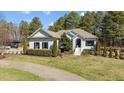 Charming white brick home with black shutters and lush landscaping providing beautiful curb appeal at 4050 Cannady Mill Rd, Kittrell, NC 27544