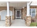Inviting home entrance featuring stone accents, white pillars and a dark front door at 413 Westfalen Dr, Cary, NC 27519