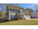Charming two-story home with blue shutters, a well-manicured lawn and a two-car garage at 424 Crystal Spring Dr, Sanford, NC 27332