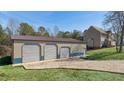 Large detached garage with three bays and gravel driveway behind the house at 424 Crystal Spring Dr, Sanford, NC 27332