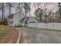 Charming two-story home with light gray siding, detached garage, and a white privacy fence at 48 Margaret Pl, Chapel Hill, NC 27516