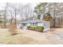 Image showcasing the exterior of a house with gray siding and blue shutters on a well-manicured lawn at 4814 Fayetteville Rd, Durham, NC 27713