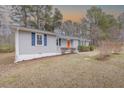 View of a cozy single-story house, featuring gray siding, contrasting trim, and well-maintained landscaping at 4814 Fayetteville Rd, Durham, NC 27713