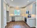 Modern kitchen with stainless steel appliances, granite countertops, and white cabinetry at 512 Hicksmill Rd, Oxford, NC 27565