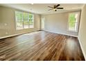 Spacious living room with hardwood floors, large windows, and a glass door to backyard at 512 Hicksmill Rd, Oxford, NC 27565