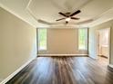 Primary bedroom with tray ceiling, ceiling fan, and large windows bringing in natural light at 512 Hicksmill Rd, Oxford, NC 27565