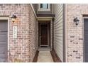 Inviting front entryway with brick accents, stylish exterior lighting, and a decorative wreath on the door at 521 Rockcastle Dr, Cary, NC 27519