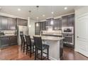 Stylish kitchen features a center island with seating, stainless steel appliances and dark cabinets for storage at 521 Rockcastle Dr, Cary, NC 27519