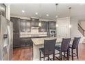 Beautiful kitchen features dark cabinetry, granite countertops, stainless appliances, and a central island with seating at 521 Rockcastle Dr, Cary, NC 27519