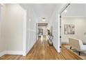Inviting hallway with wood floors, white wainscoting, and an open view of the living spaces at 5213 Bent Leaf Dr, Raleigh, NC 27606
