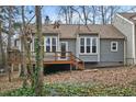 Back exterior view of the home with a wooden deck and lush greenery at 5738 Sentinel Dr, Raleigh, NC 27609