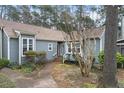 Charming home featuring a brick walkway, mature trees, and blue siding at 5738 Sentinel Dr, Raleigh, NC 27609