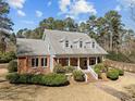 Two-story brick home with a welcoming front porch, manicured landscaping, and mature trees in a great location at 6336 Wrenwood Ave, Raleigh, NC 27607