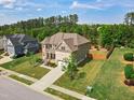 Spacious home with a lush lawn and mature trees, showcasing its desirable neighborhood location at 701 Prince Dr, Holly Springs, NC 27540