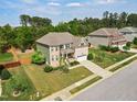 Residential home featuring a well-manicured lawn, mature trees, and a convenient two-car garage at 701 Prince Dr, Holly Springs, NC 27540