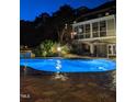 This outdoor pool at night features ambient lighting and access to the home's screened porch at 705 Glen Eden Dr, Raleigh, NC 27612