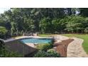 Beautiful backyard pool with stone accents, lush landscaping, and an inviting outdoor lounge area at 705 Glen Eden Dr, Raleigh, NC 27612