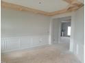 Unfinished dining room featuring elegant wainscoting, light gray walls, and a decorative wood beam ceiling at 72 Cultivator Ct, Angier, NC 27501