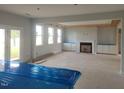 Bright unfinished living room features lots of windows, a fireplace, and lots of space to entertain guests at 72 Cultivator Ct, Angier, NC 27501