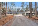 Charming single-story home with a long driveway and a large front yard surrounded by mature trees at 7214 Southern Trl, Chapel Hill, NC 27516