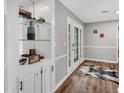 A hallway with hard wood floors, white french doors, and a built in display case with glass shelves at 7214 Southern Trl, Chapel Hill, NC 27516