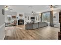 Spacious living room with wood floors, large windows, a gray sofa and a fireplace at 7214 Southern Trl, Chapel Hill, NC 27516