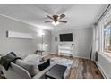 Cozy living room with a ceiling fan, wood floors, neutral paint, and large window views at 749 Fred Royster Rd, Henderson, NC 27537