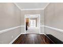 Hallway leads to carpeted living room featuring a brick fireplace and large windows at 8724 Ten Ten Rd, Raleigh, NC 27603