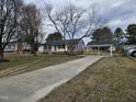 Charming one story home with a blue front door, gray siding and a long drive at 912 Hillsboro St, Oxford, NC 27565