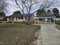 Charming one story home with a blue front door, gray siding and a long drive at 912 Hillsboro St, Oxford, NC 27565